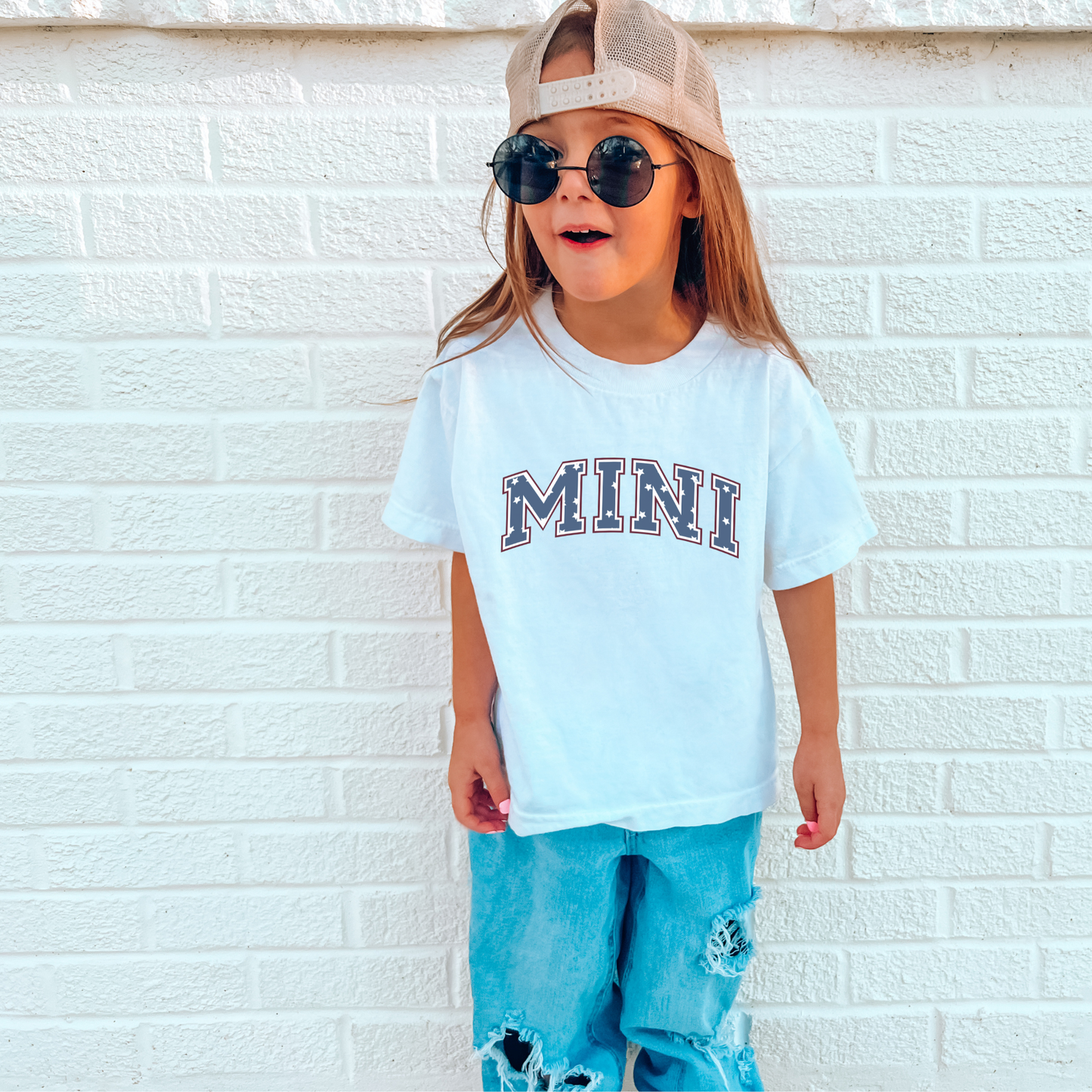 a little girl wearing a hat and sunglasses