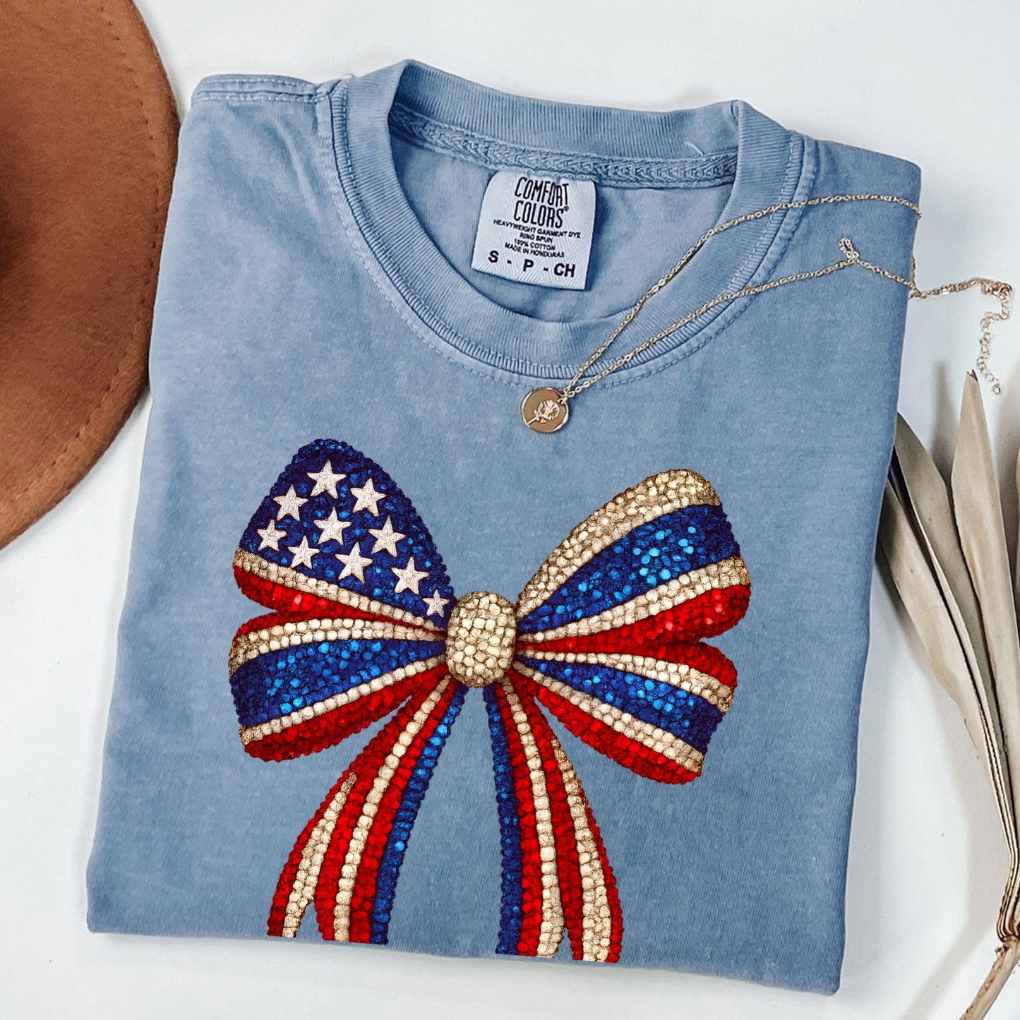 a blue t - shirt with a red, white, and blue bow on it