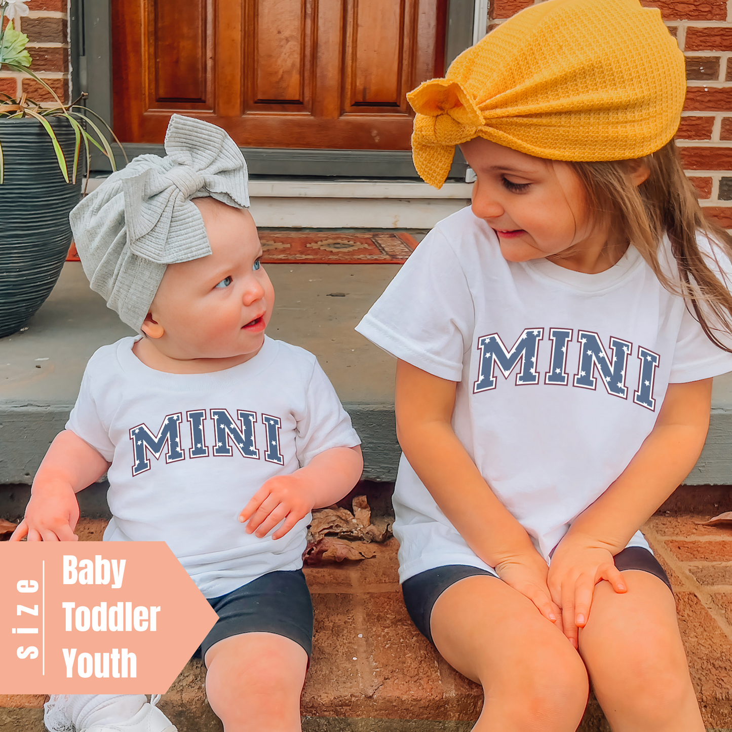 two little girls sitting on a step together