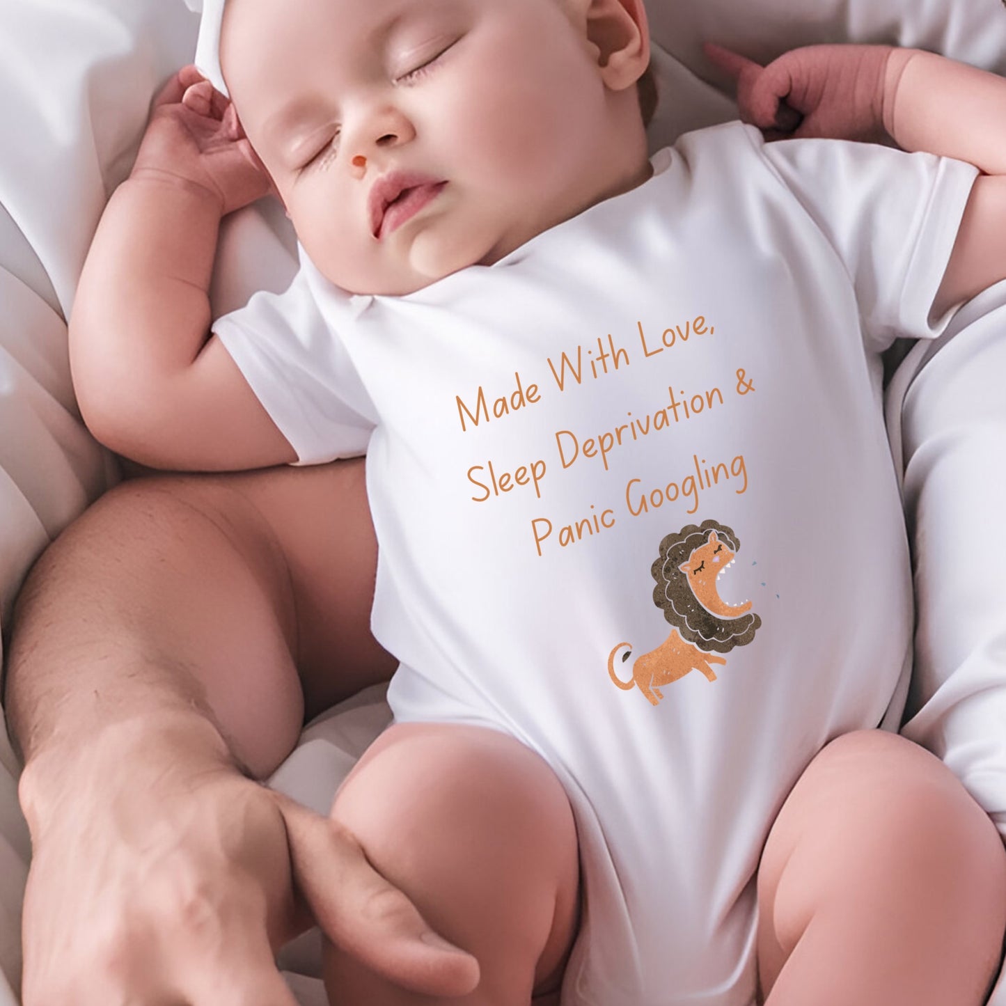 a baby sleeping on a bed with a lion on it