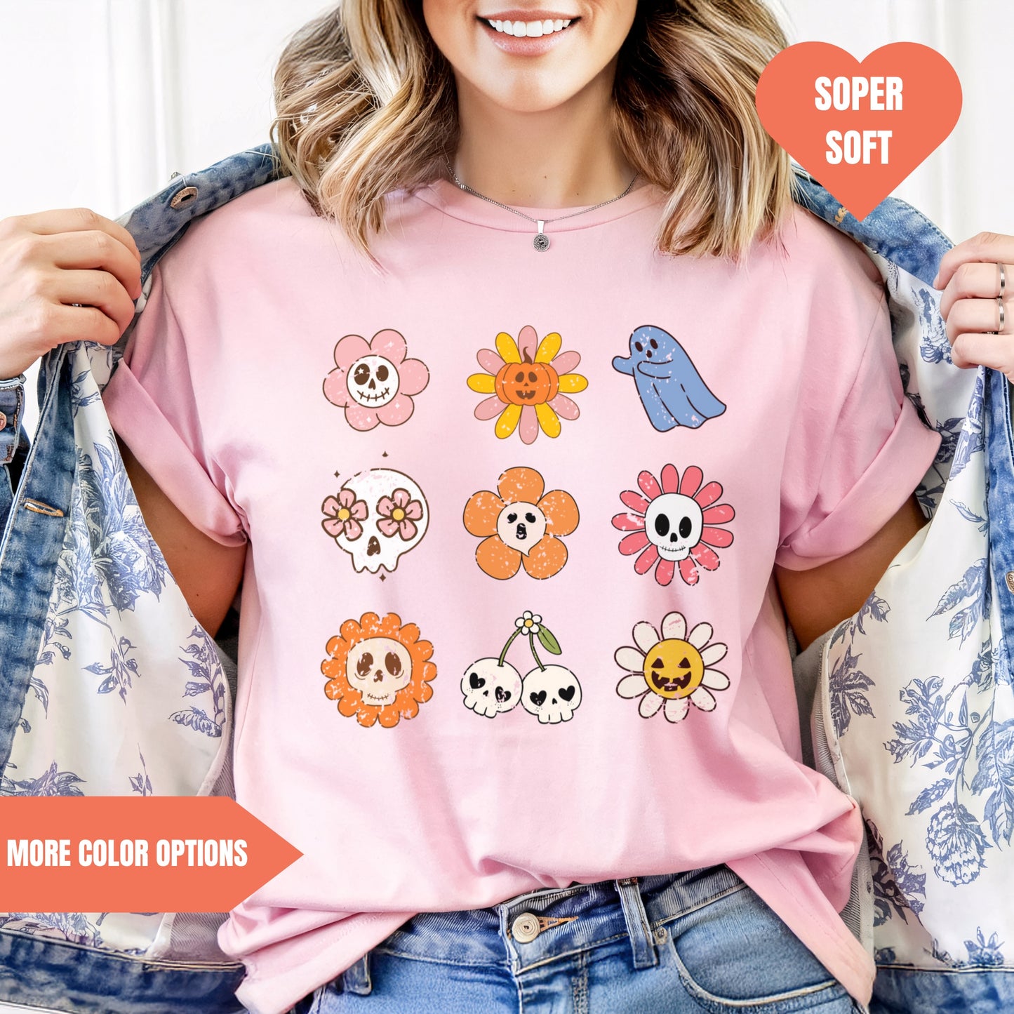 a woman wearing a pink t - shirt with flowers and skulls on it