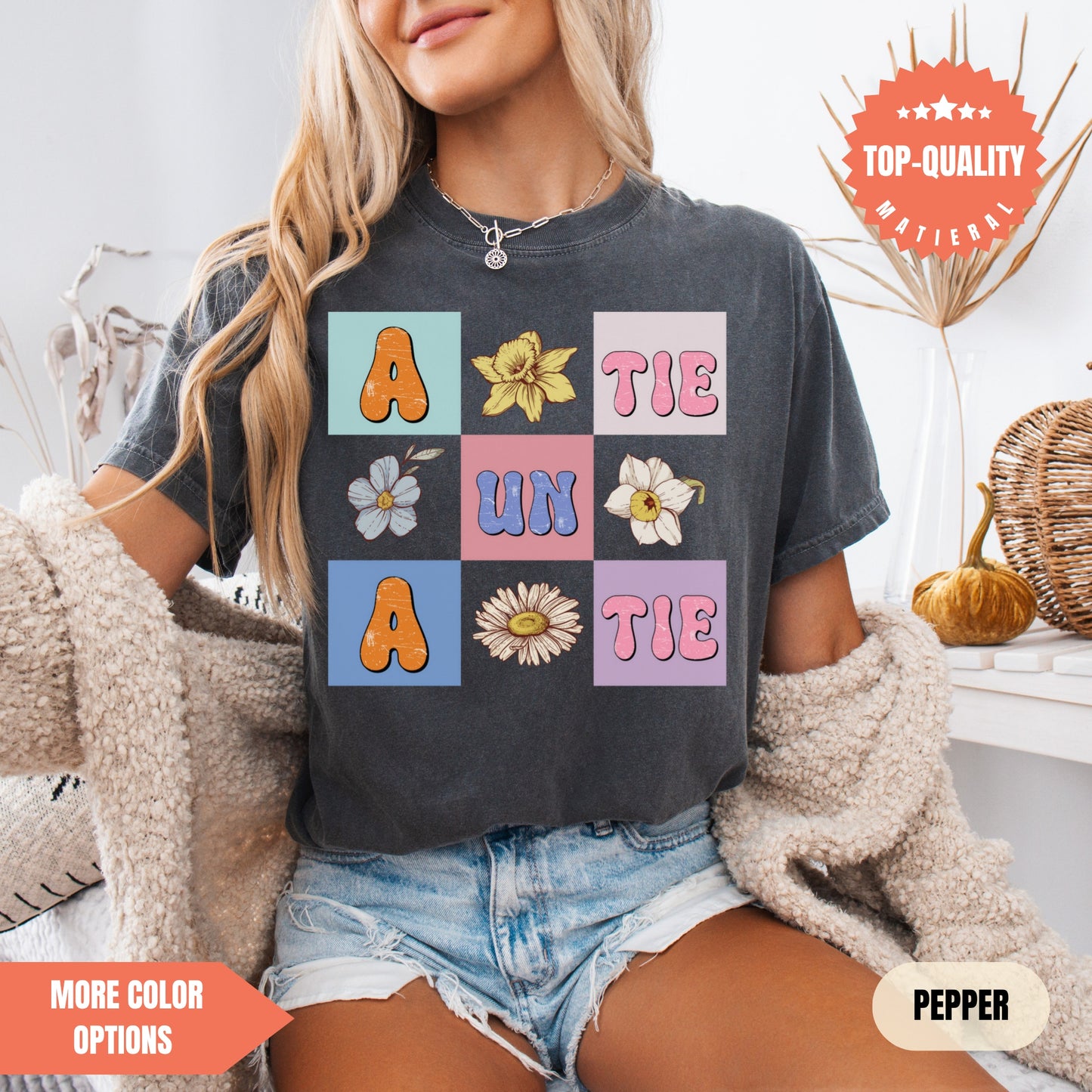 a woman sitting on a bed wearing a t - shirt with flowers on it