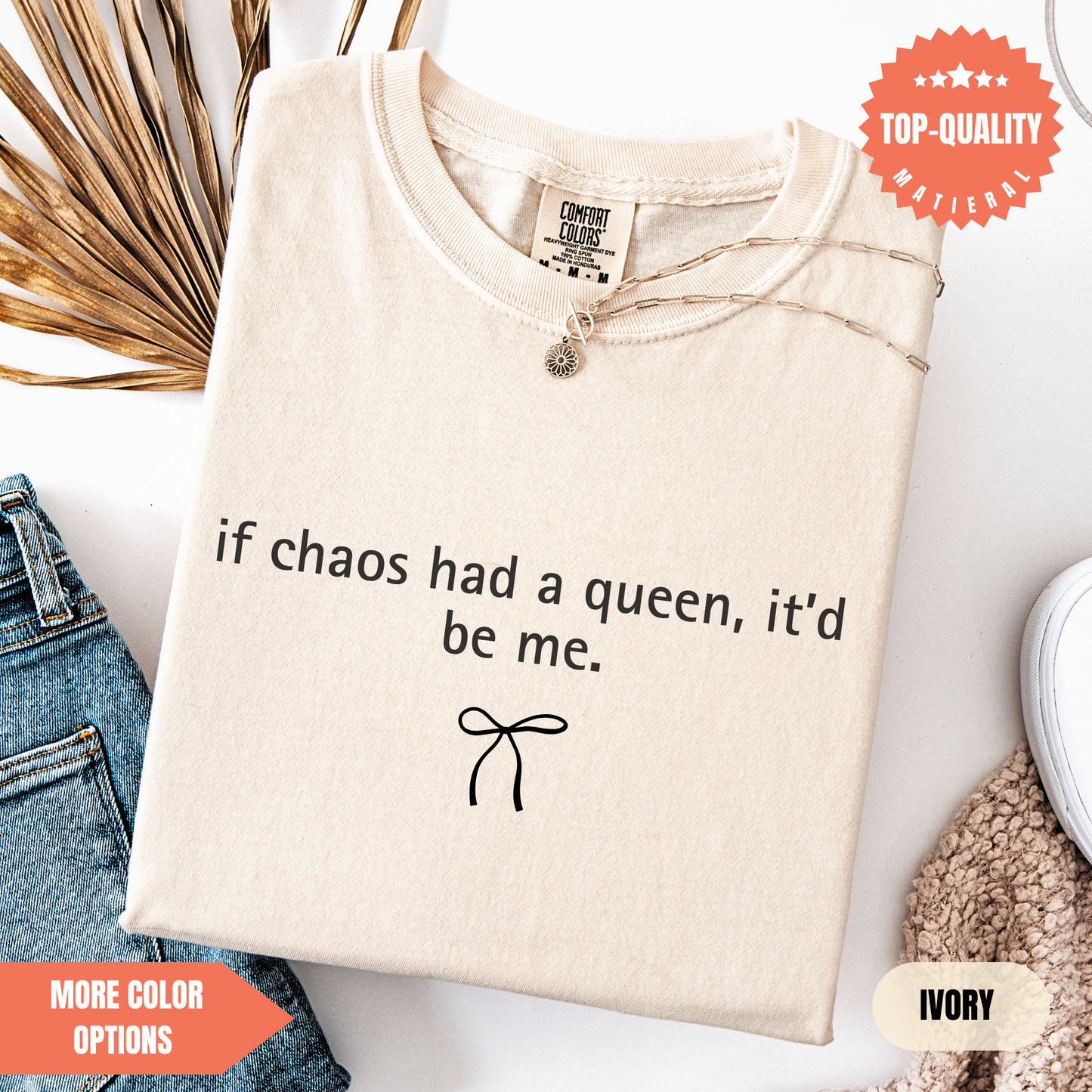 a beige t-shirt with a humorous text printed on it, along with a small bow and some other clothing items.