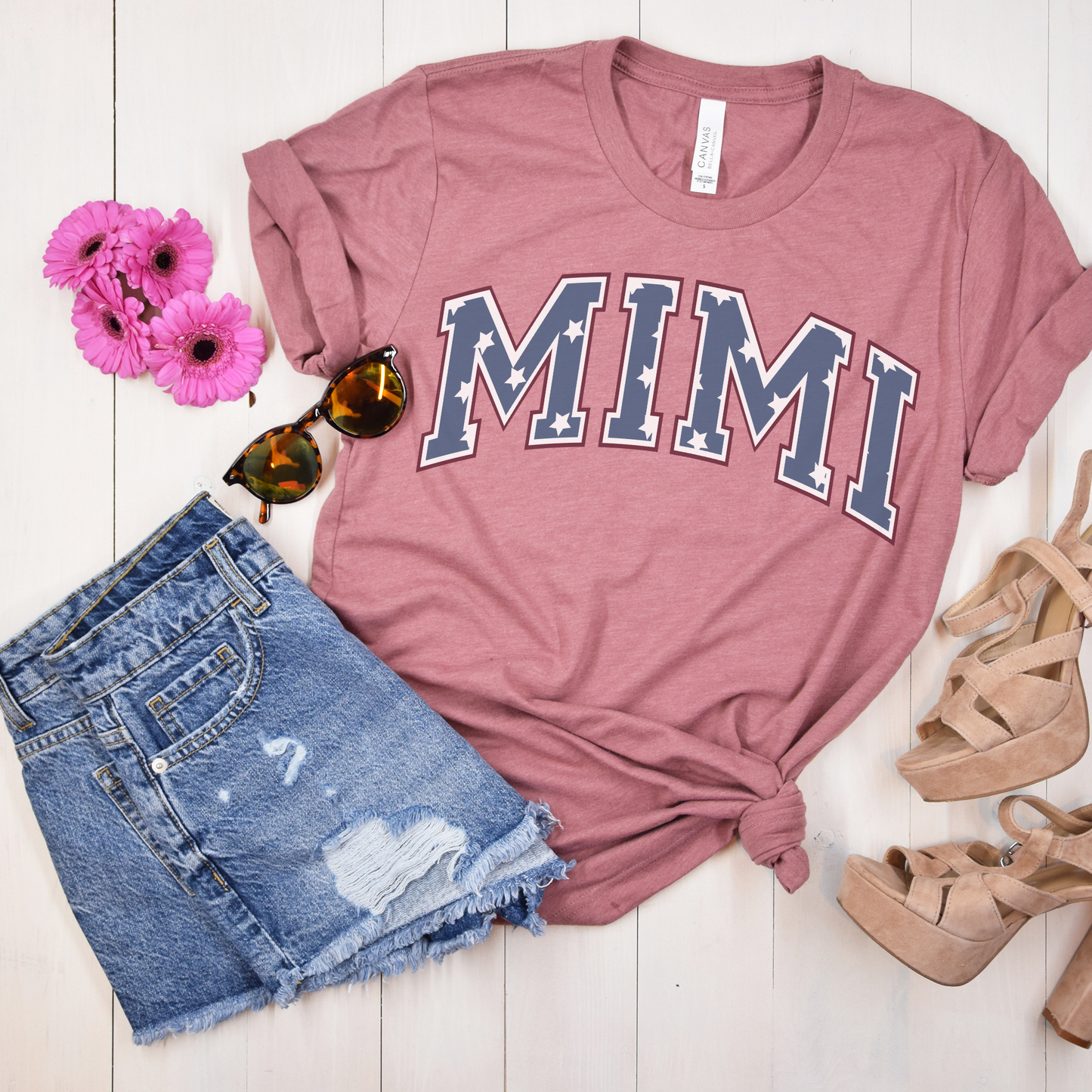 a pink shirt with the word mmm on it next to a pair of shorts and