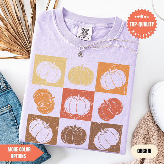 a t - shirt with pumpkins on it next to a pair of jeans