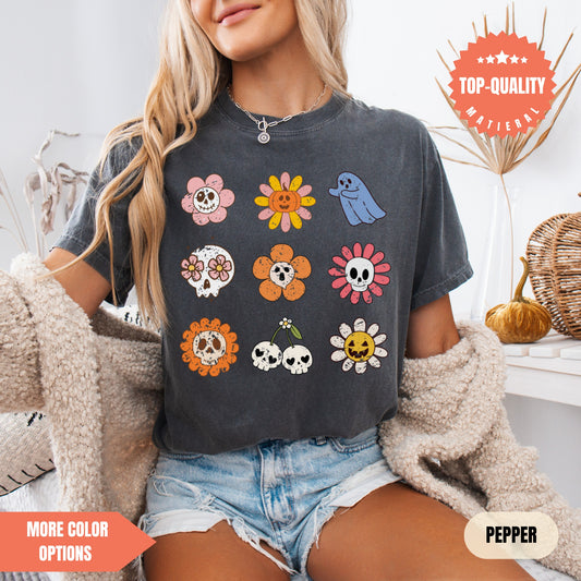 a woman sitting on a bed wearing a black shirt with skulls and flowers on it