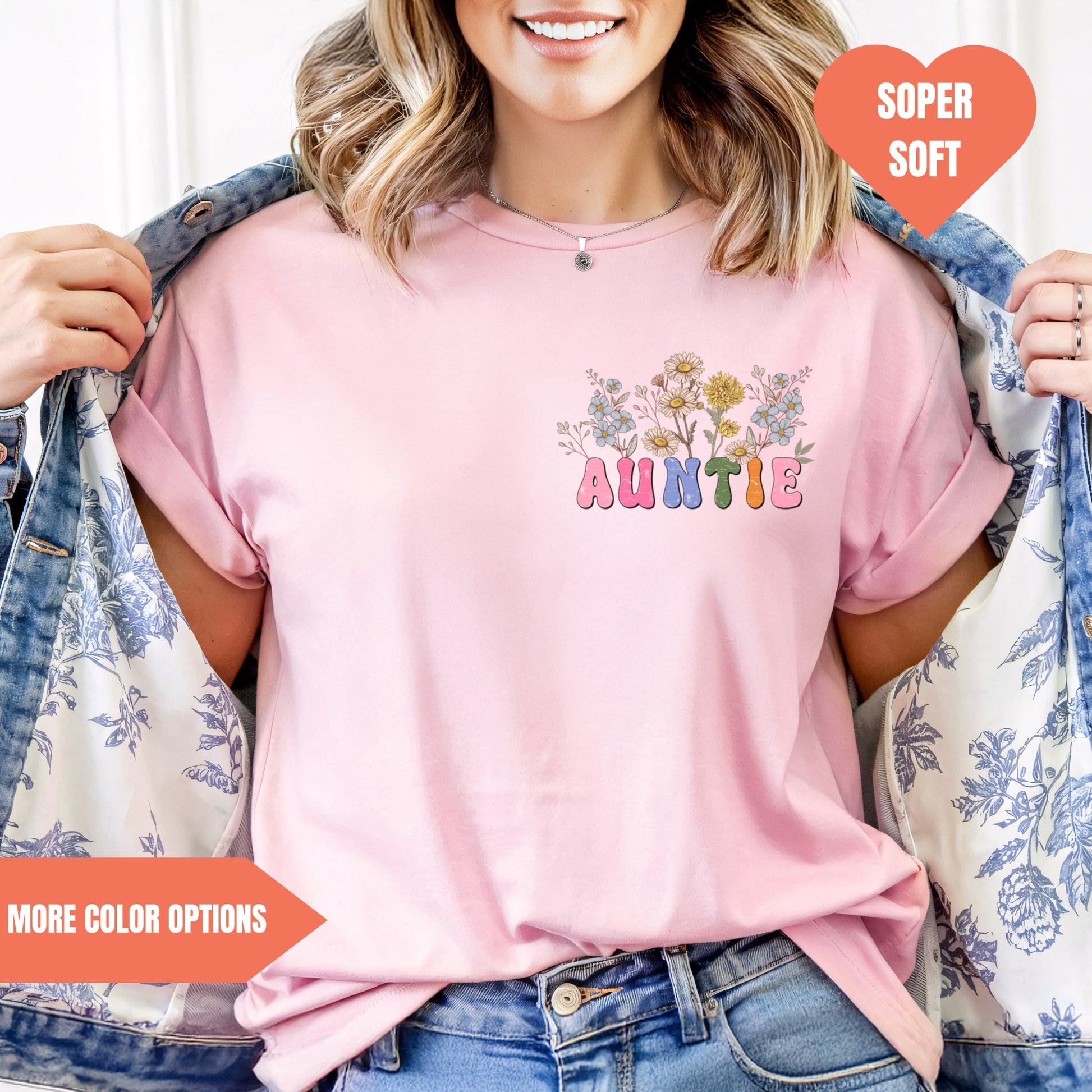 a woman wearing a pink t - shirt with a flower design on it