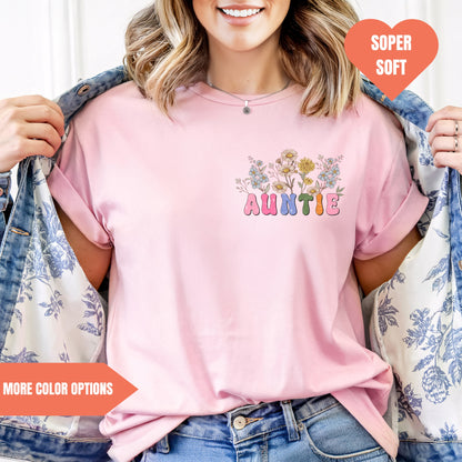 a woman wearing a pink t - shirt with a flower design on it