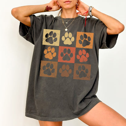 a woman wearing a t - shirt with a dog's paw prints on it