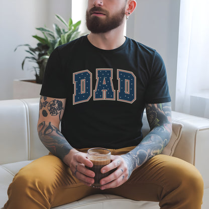 a man with tattoos sitting on a couch holding a cup of coffee