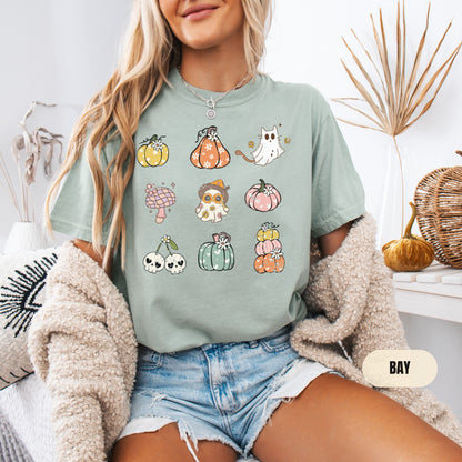 a woman sitting on a bed wearing a t - shirt with a bunch of pumpkin