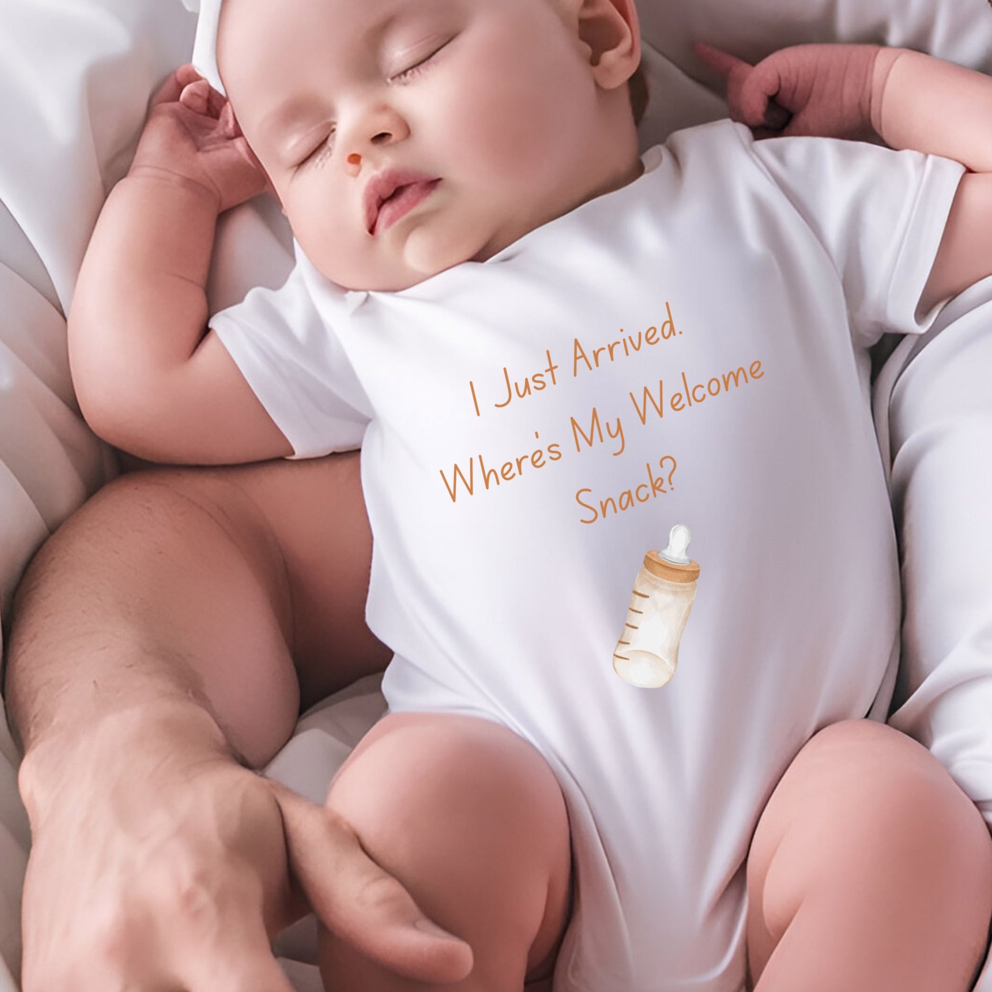 a baby sleeping on a bed wearing a white bodysuit
