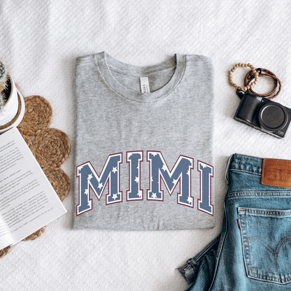 a t - shirt with the word mimi on it next to a pair of jeans